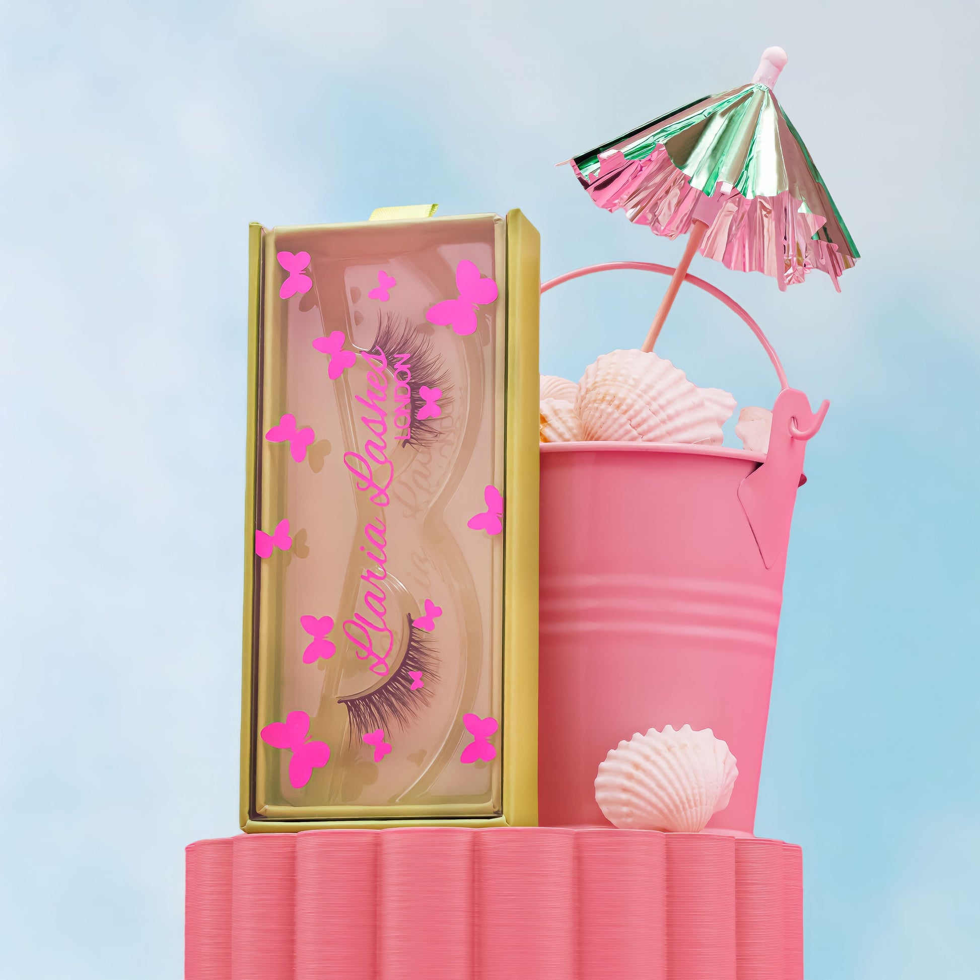 Pink makeup product with butterfly decorations on a light blue background